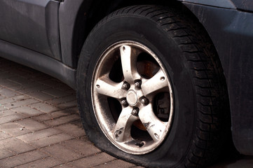 Car wheel flat tire on the road. Road accident