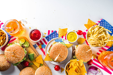 Celebrating Independence Day, July 4. Traditional American Memorial Day Patriotic Picnic with burgers, french fries and snacks, Summer USA picnic and bbq concept, White concrete background
