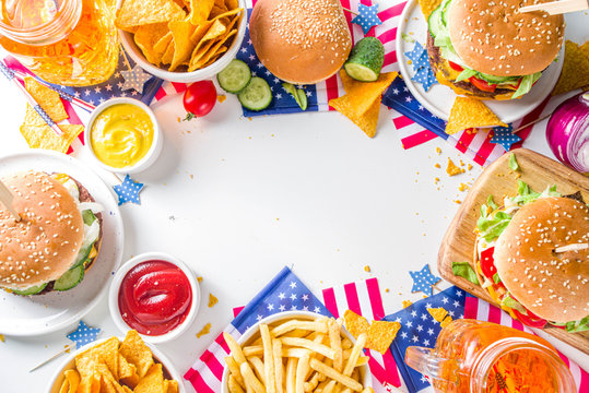 Celebrating Independence Day, July 4. Traditional American Memorial Day Patriotic Picnic with burgers, french fries and snacks, Summer USA picnic and bbq concept, White concrete background