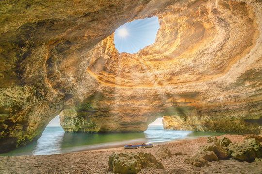 Inside view of the Benagil Sea Cave on Praia de Benagil, Benagil Beach Algarve Portugal. Sun is shining in the cave. Romantic and protect nature concept.
