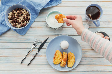 Breakfast with fried croutons, yogurt and black tea on light wooden background. Summer country food.