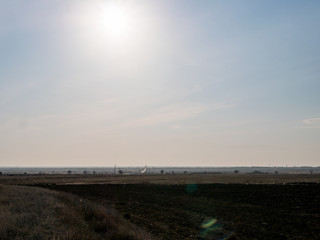 Shining in sunlight road through bridge. Calm summer rural landscape. Cars moving on road