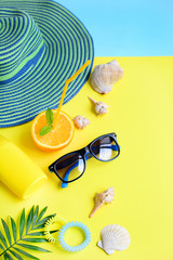 Vertical composition of things for a beach holiday, seashells, palm branches on a yellow...