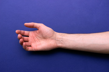 man put his hand and shows his veins on a blue background