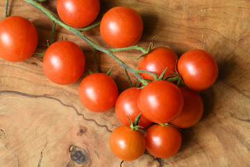 Fresh tomatoes on wood background. Closeup of fresh tomatoes on olive tree wooden background.