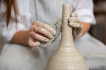 Ceramist working on the wheel of a potter making a vase. Making ceramic utensils. The master handles jug, giving it the correct shape. Craftsmanship