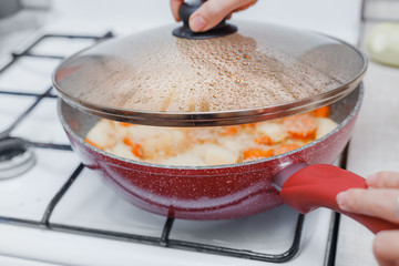 Water droplets formed under the lid of the pan while cooking vegetable stew or soup. Cooking at home and recipes - obrazy, fototapety, plakaty