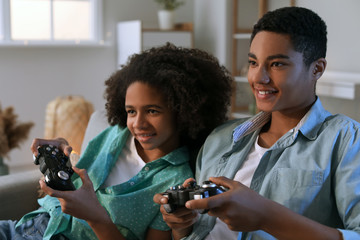 African-American teenagers playing video game at home