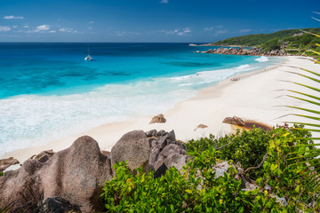 Petite Anse, La Digue in Seychelles - Tropical and paradise beach. Yacht boat at anchor in blue...