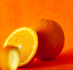 soft focus of whole and cut juicy citrus fruit on orange background