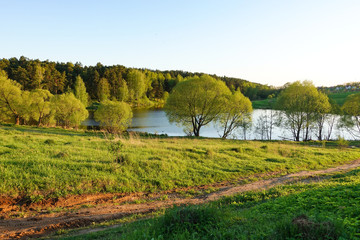 Beautiful countryside landscape. Green meadow and river in the evening. Summer. Russia.