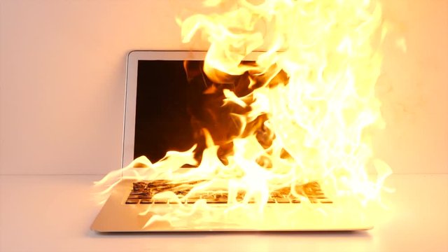 Large burst of flames on overheating laptop.  Intense fire as the computer burns.