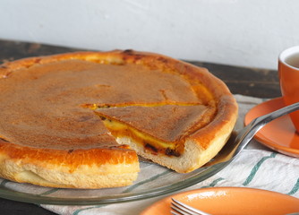 Home cooking.Orange pumpkin round pie. Natural vegetarian dessert on a dark wooden background.