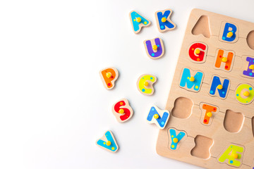 Wooden kid game board with letters of the alphabet. Concept of early learning children reading....
