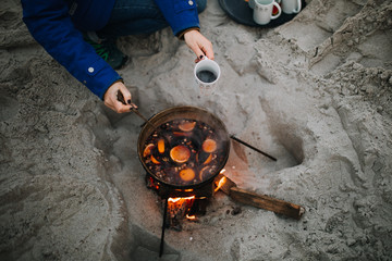 photo of a woman drinking hot wine at the beach
