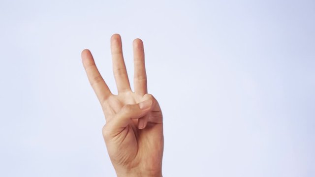 closeup male hand isolated on a white background three fingers raised up