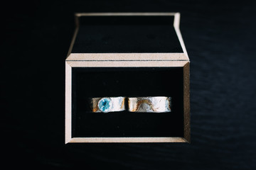 photo of wedding rings in a box with black background