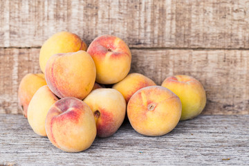 Peach fruits isolated on wooden background