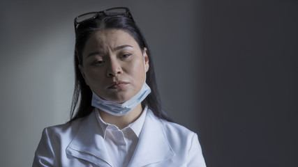 Tired overworked doctor feels stress. Exhausted by overtime work female medic resting from...