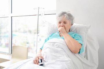 Coughing elderly woman in hospital room