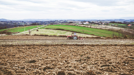 Rural agricultural landscape, tractor ploughing a field