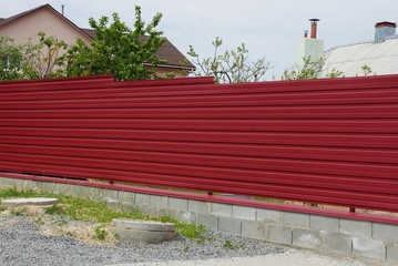 long red metal fence wall on a rural street