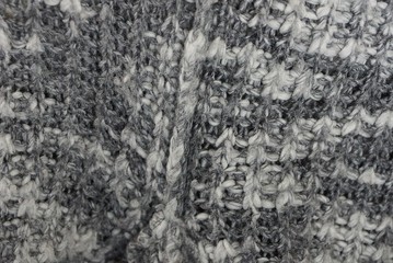 gray white texture of a piece of spotty woolen clothing with a seam