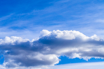 Naklejka na ściany i meble Bright contrasting blue sky with white fluffy clouds