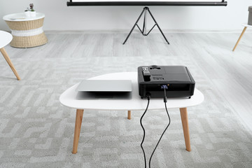 Modern video projector and laptop in room