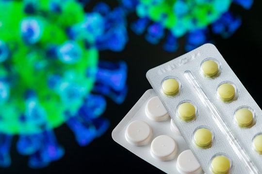 Pills and tablets on the background image of a coronavirus. Healthcare concept.