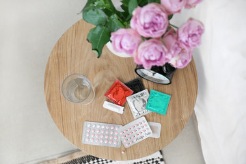 Different means of contraception and clock on table