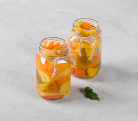 Vegetable appetizer pickled peppers in a jar on a light background in rustic style