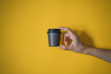 mano de mujer sujetando un vaso de cartón para llevar, cafetería