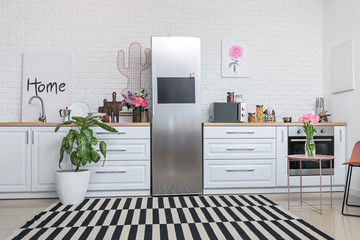 Fototapeta na wymiar Stylish interior of modern kitchen with big refrigerator