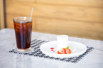 Cheesecake and Iced Coffee with Wooden Background