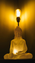 Figura budista a la luz de una lampara