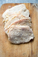 Preparing breaded pork chops, polish kotlety. Covering meat in bread crumbs 