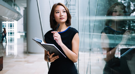 Thoughtful Asian woman looking out of window