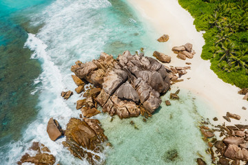 Seychelles La Digue Island. Aerial view of ocean waves and huge granite rocks on the tropical beach...