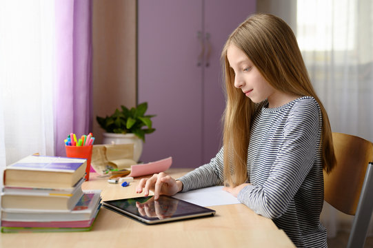 Online home lesson. The girl is engaged in a lesson at home. Observing social distance. - Powered by Adobe