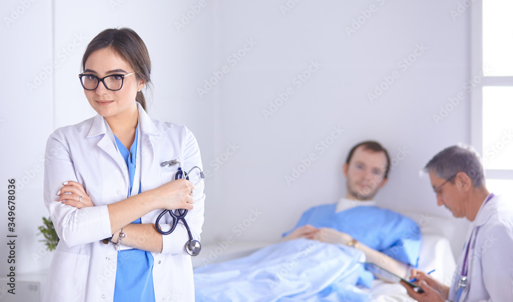 Wall mural Doctor checking heart beat of patient in bed with stethoscope