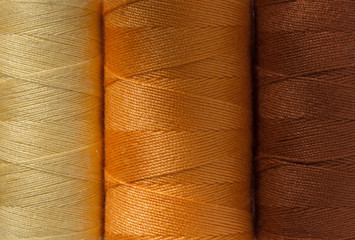 three spools of thin cotton threads of stylish natural colors