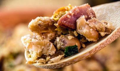 wooden spoon with portion of tropical beans, typical Brazilian food, primer plan, spot focus.