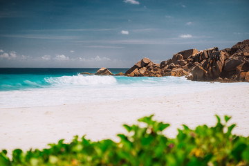 Ocean foamy waves and white sand beach at Petite Anse, La Digue in Seychelles