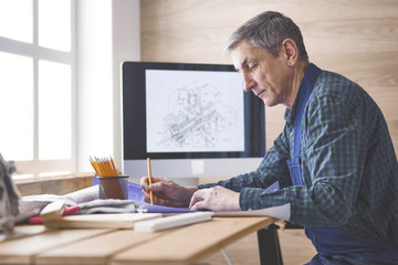 Engineer carpenter working on laptop and sketching project