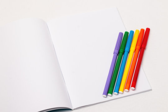 LGBT flag with markers on blank notebook