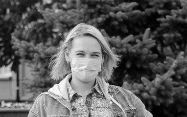 A young girl in a pink cloth protective mask during the covid-19 epidemic in the park.