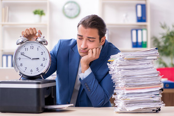 Young male employee making copies at copying machine