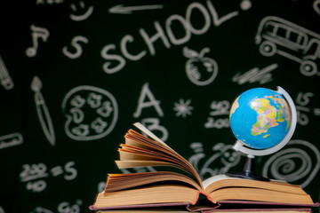 Book stack on a green blackboard background, back to school concept
