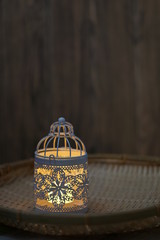 Traditional lamp and ketupat on Asian textured background